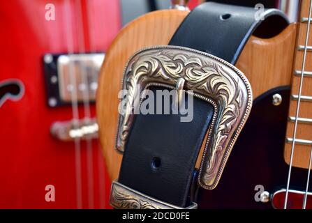 Electric guitars and leather strap with silver buckle close-up. Stock Photo