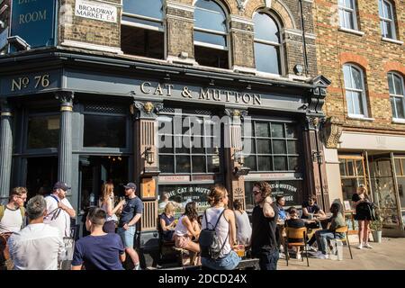 People sitting at an outdoor table of Cat & Mutton pub on Broadway Market, a shopping street in the heart of Hackney, East London, UK Stock Photo