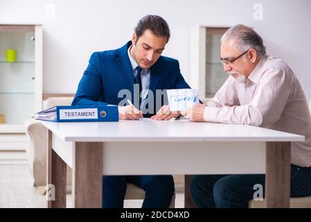 Young lawyer visiting old man in testament concept Stock Photo