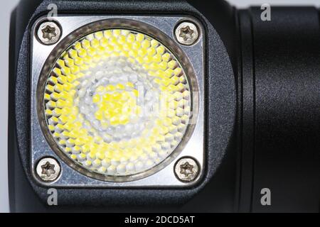 Black metal led headlamp flashlight with a lens close up. Anodized knurled aluminum grip Stock Photo