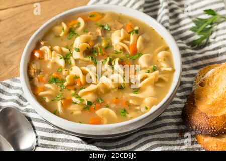 Homemade Chicken Noodle Soup with Peas and Carrots Stock Photo