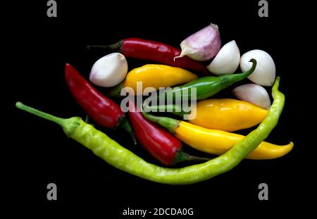 Chilies and cloves of garlic on black background Stock Photo