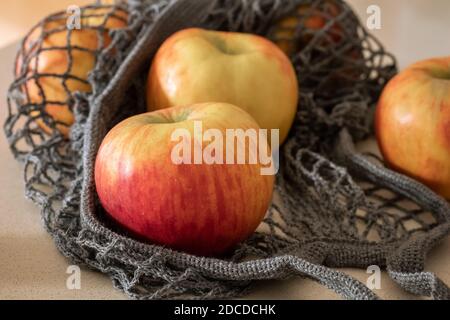 Fresh apples in a net bag on a table Stock Photo