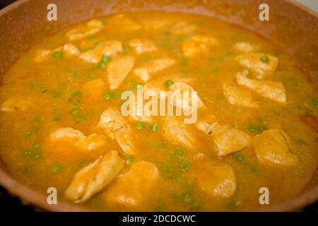 Chicken korma with pees cooking in a skillet Stock Photo