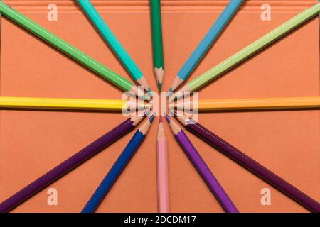 Colored pencils joined in a circle in the middle of a textbook cover. Stock Photo