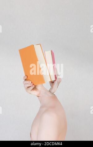 Abstract portrait of two hands holding books coming out of young body head on a textured background. Stock Photo