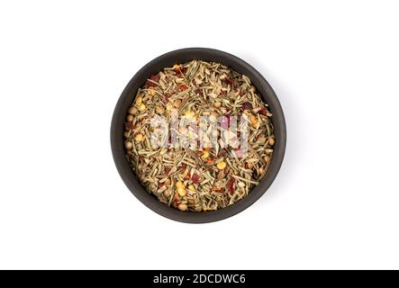A mixture of dried herbs and peppers for cooking in a round bowl on a white background. Stock Photo
