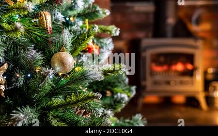 Close up of christmas tree bobbles with blured out fire in background. home living room shallow depth of field Stock Photo