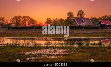 Traditional farm located along a river and ponds. The sun is setting in this Dutch farm landscape located near the small neighbourhood called Tusveld Stock Photo