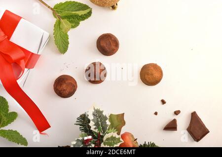 Christmas composition with chocolate truffles on white table with gift and Christmas decoration. Top view. Horizontal composition. Stock Photo