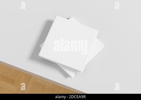 Square white hardcover book stack mockup on the white table Stock Photo