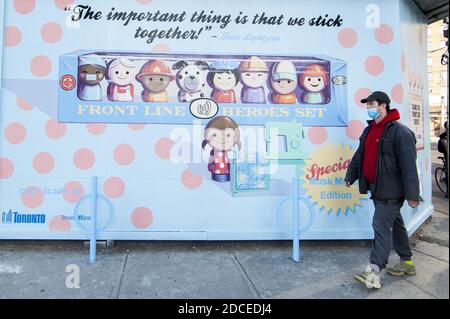 Toronto, Canada. 20th Nov, 2020. A man wearing a face mask walks past a mural thanking frontline workers in Toronto, Canada, on Nov. 20, 2020. Canadian Prime Minister Justin Trudeau said on Friday that the country is at stake as COVID-19 has been worsening. As of Friday afternoon, Canada reported a total of 319,038 cases and 11,313 deaths. Credit: Zou Zheng/Xinhua/Alamy Live News Stock Photo