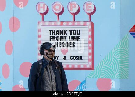 Toronto, Canada. 20th Nov, 2020. A man wearing a face mask walks past a mural thanking frontline workers in Toronto, Canada, on Nov. 20, 2020. Canadian Prime Minister Justin Trudeau said on Friday that the country is at stake as COVID-19 has been worsening. As of Friday afternoon, Canada reported a total of 319,038 cases and 11,313 deaths. Credit: Zou Zheng/Xinhua/Alamy Live News Stock Photo