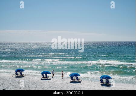 Two people walking on the white sand beach and beaches of the Florida panhandle, Gulf of Mexico, in Seaside Florida, USA. Stock Photo