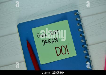 Don't Just Dream - DO! write on sticky note isolated on Wooden Table. Stock Photo