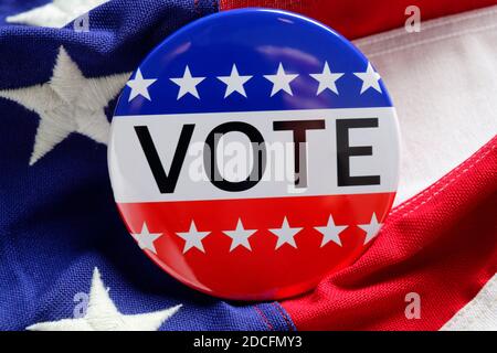 A red, white and blue VOTE button on a blue background Stock Photo
