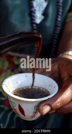 Woman pouring Ethiopian coffee into traditional coffee cup Stock Photo