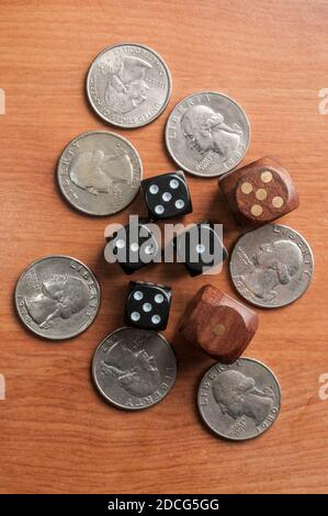 Quarter coins and dice on a wooden table Stock Photo