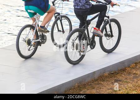 man and  woman by bicycles go on embankment Stock Photo