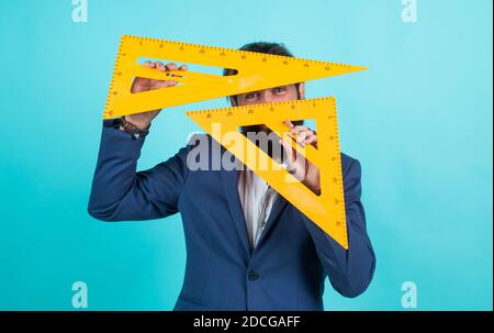 businessman in suit using in work geometric tool of triangle ruler, engineering. Stock Photo