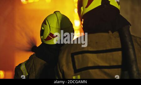 Firefighters extinguish fire with the hose. Burning house fire drill. High quality photo Stock Photo
