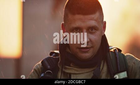 Portrait of young heroic fireman in front of burning house. High quality photo Stock Photo