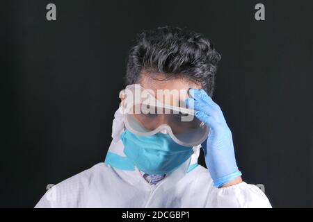 sad matured doctor covering face with hands isolated on black  Stock Photo