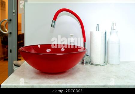 Glass red sink and red faucet in a modern bathroom Stock Photo