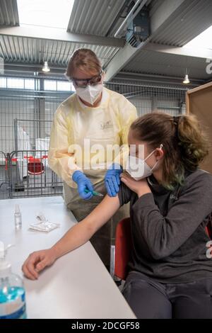 21 November 2020, Baden-Wuerttemberg, Ulm: Dorothea Gansloser (l) and Kim Gühler simulate a vaccination in the exhibition centre. The German Red Cross rehearsed the procedure for the vaccination of a corona vaccine in the vaccination centre planned for the state of Baden-Württemberg among others. In Ulm, it should be possible to vaccinate up to 120 people per hour. Photo: Stefan Puchner/dpa Stock Photo