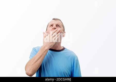 Sleepy young middle aged yawning covering his mouth with hand isolated on white background feeling. Tired  middle aged needs to sleep isolated on whit Stock Photo