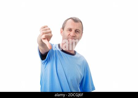 Displeased middle aged man showing thumbs down, negative gesture and bad feedback, looking to camera isolated on white wall background. Stock Photo