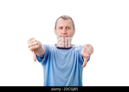 Displeased middle aged man showing thumbs down, negative gesture and bad feedback, looking to camera isolated on white wall background. Stock Photo