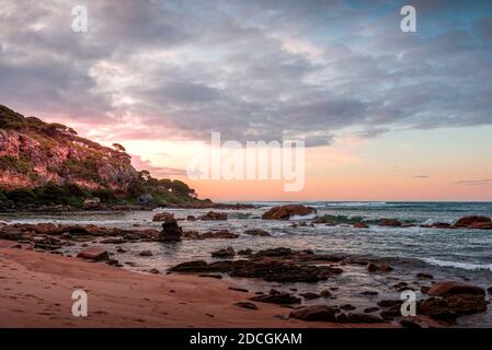 A coastal scene at sunset on a rocky shore Stock Photo