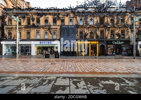 Glasgow, Scotland, UK. 21 November 2020. Views of Saturday afternoon in Glasgow city centre on first day of level 4 lockdown. Non essential shops and businesses have closed. And streets are very quiet. Pictured;  Buchanan Street shopping precinct is almost deserted with no shops open including Princes Square here .Iain Masterton/Alamy Live News