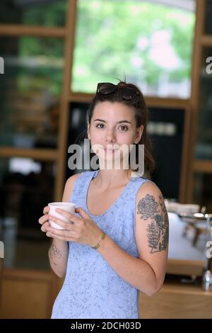 Germany / Berlin /Coffee Style /Girl with tattoo drinking coffee at Bonanza Roastery Cafe in Berlin.