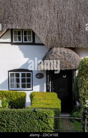 Front Of A Thatched Cottage With Windows And Black Front Door And Thatched Porch English 18th Century Thatched Cottage, Grade 2 Listed. Swan Green Cot Stock Photo