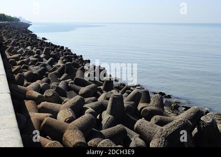 Concrete wave breakers along promenade on coastline near Marine drive road. Back Bay is part of Arabian sea near Mumbai, India. Stock Photo