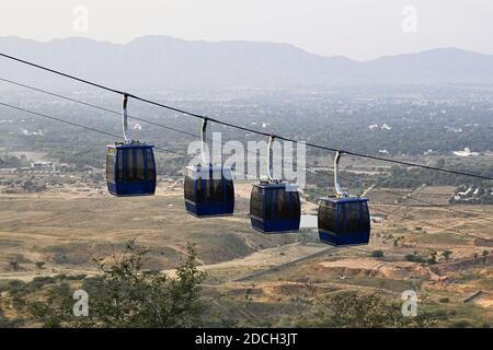 Four hanging cabins of the ropeway to the Savitri Mata Temple on the hill near Pushkar city, Rajasthan, India Stock Photo