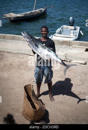 Sales man holding Fresh raw barracuda fish in market Stock Photo