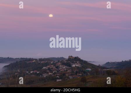 Full moon and pink clouds over Mornico Losana in oltrepo pavese during autumn Stock Photo