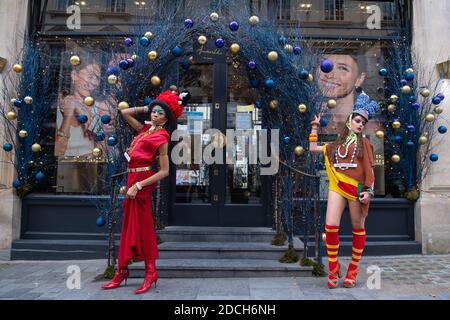 Models stand amongst Christmas decorations as they showcase clothes by fashion designer Pierre Garroudi during a flashmob fashion shoot on Oxford Street London Stock Photo Alamy