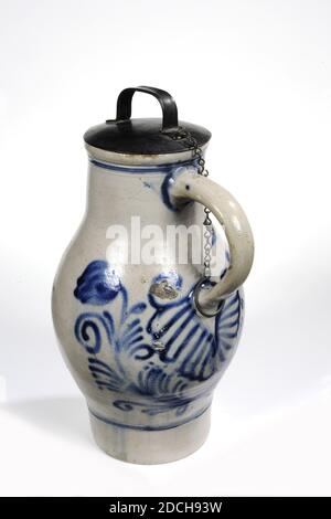 jug, Anonymous, 18th century, tin, stoneware, metal, baked, With lid: 41 x 21.5 x 26cm 410 x 215 x 260mm, Without lid: 36 x 21.5 x 26cm 360 x 215 x 260mm, Flower, A large jug with stoneware handle, with a tin lid. The lid is attached to the ear with a link chain and a round hook. The edge of the neck is pinched into a pouring spout. The lid has a protruding lob that precisely covers the spout. On the lid is a handle, also made of tin. The jug is painted on the side of the ear with a floral decoration in blue. A thin blue stripe is painted at the bottom of the belly and at the top of the neck Stock Photo