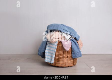 a pile of colorful clothes in a wicker Laundry basket Stock Photo