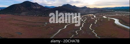 Narrow channels meander through a beautiful estuary in Central California. Estuaries form when freshwater runoff meets and mixes with seawater. Stock Photo