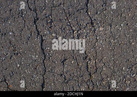 cracked across flat gray dry asphalt texture Stock Photo