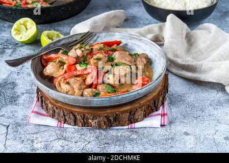 Indonesian-style chicken in peanut butter sauce with red peppers and coriander Stock Photo