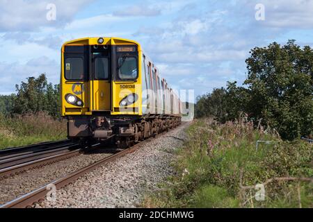 Merseyrail Electrics class 508 third rail electric trains 508138 + 508126  passing Bowkers Green on the Northern line Stock Photo