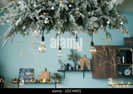 Incandescent lamps among the Christmas garland in the kitchen, decorated for Christmas and New Year Stock Photo