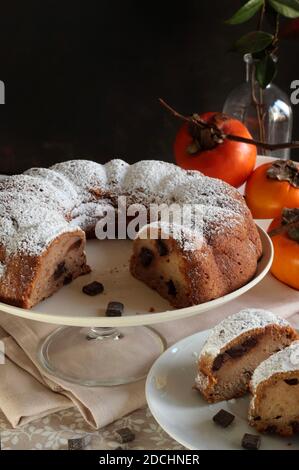 Bundt cake with persimmon, served on table. Selective focus. Stock Photo
