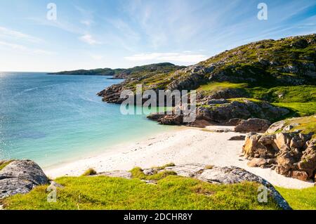 A view of a white sand beach on the shore of Achmelvich Bay in the far north of Scotland. June. Stock Photo